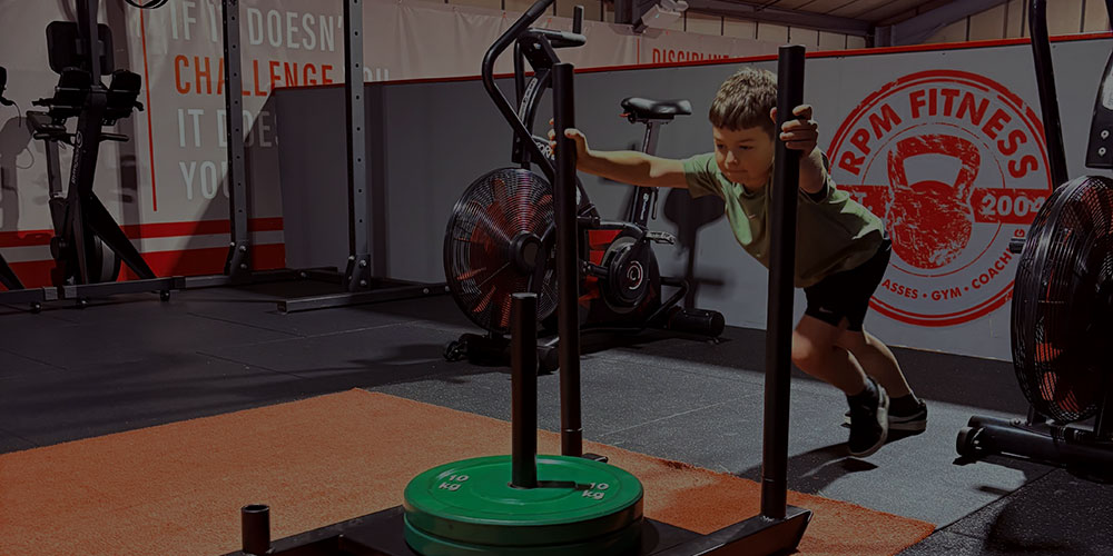 Child using sled in gym